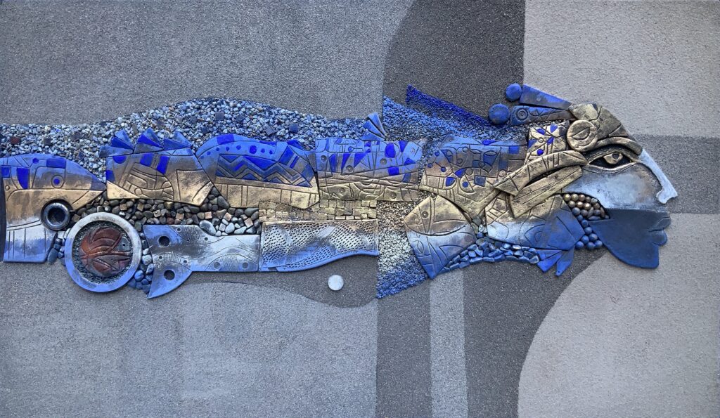 Escultura mural contemporánea inspirada en el arte mesoamericano, compuesta por un mosaico de relieves, texturas y formas geométricas que evocan figuras humanas y elementos simbólicos. La obra combina tonos metálicos y azules intensos con piedra y superficies grabadas, creando una narrativa visual que recuerda a los antiguos murales y esculturas prehispánicas. Una pieza única de arte decorativo ideal para espacios modernos, galerías o colecciones de arte latinoamericano.